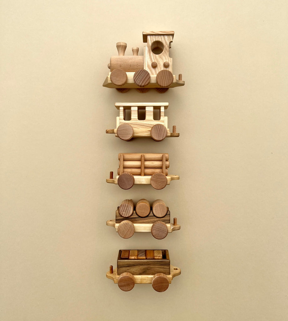 A vertical display of various Handmade Wooden Train - Extra Long components arranged on a light beige background, showcasing different car designs including engines and passenger cars.