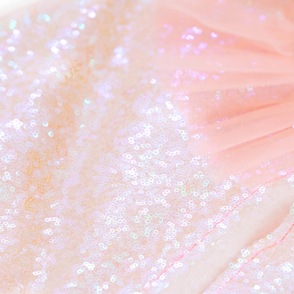 Close-up of a Meri Meri Iridescent Sequin Cape Costume with a gradient from pink to ivory, covered in shimmering sequins that catch the light.