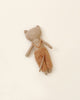 A worn-out fabric Maileg Cat Stuffed Animal from the Best Friends Collection with a beige and brown color scheme lying flat against a plain light beige background. The bear's head and limbs are floppy, suggesting softness.