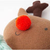 Close-up of Jingles The Reindeer Toy, focusing on its red, fuzzy nose. The reindeer is made of brown fabric with darker brown antlers and small black eyes. A part of a soft knitted light blue item is visible on the left.