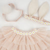 Flat lay image of a Meri Meri Peach Tulle Bunny Costume including a pink tutu with daisy decorations, bunny ears headband, and a bunny tail on a white background.
