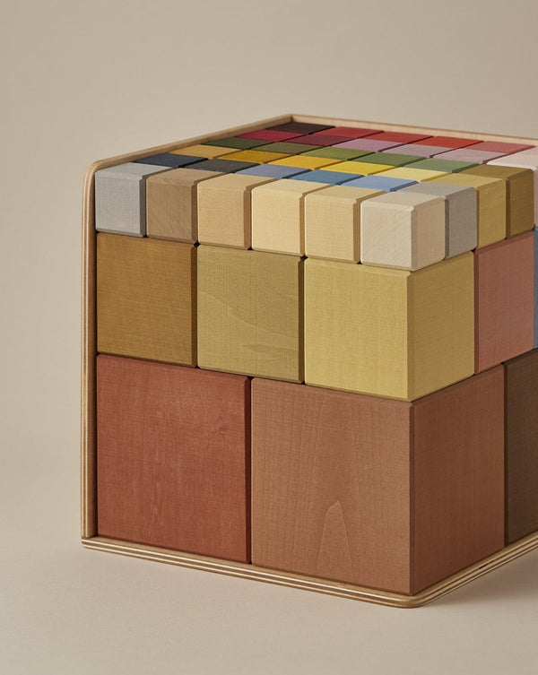 A close-up image of Raduga Grez Big Cube Block Set configured into a wooden puzzle cube, featuring a variety of colors on the top surface and monochromatic wooden hues on the sides.