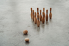 Wooden bowling set laying on the floor. 10 wooden bowling pins and 2 wooden bowling balls. 