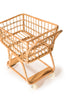 A small, empty Rattan Grocery Shopping Cart with a wooden frame and four small wheels, isolated on a white background.